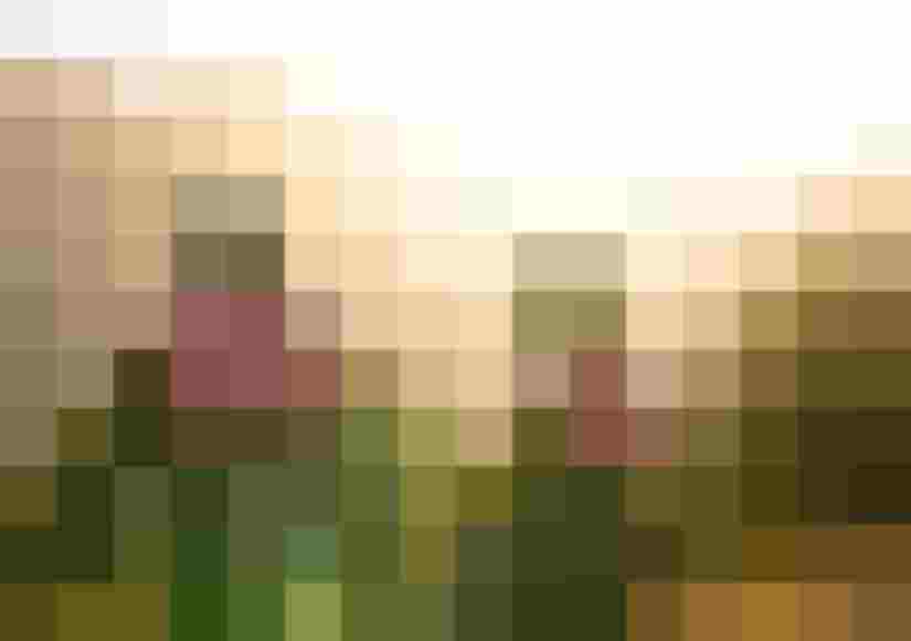 Mountainbiker in G-Out Tuning outfit voor een schilderachtig berglandschap bij zonsondergang.